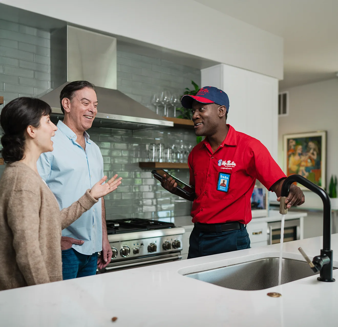Mr. Rooter professional talking to two customers about their water filter.