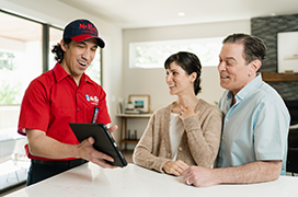 Mr. Rooter employee talking with two customers.