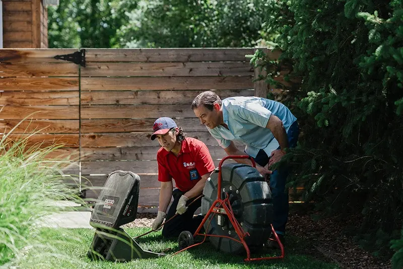 Mr. Rooter plumber showing a customer his findings during a sewer camera inspection service.