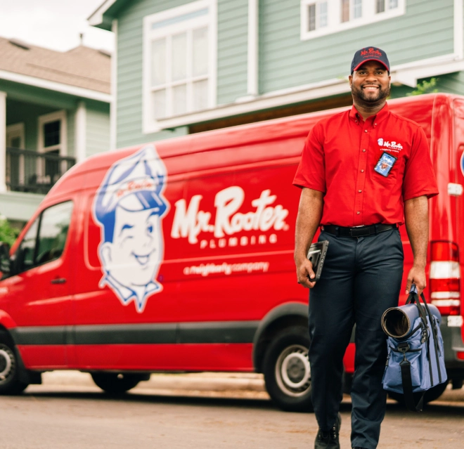 Mr. Rooter plumber holding video camera plumbing inspection equipment.