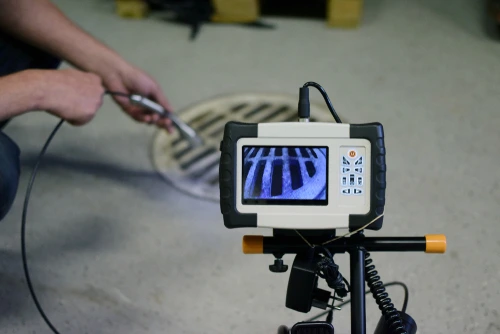 Professional plumber using video camera inspection to clear clogged drain tile.