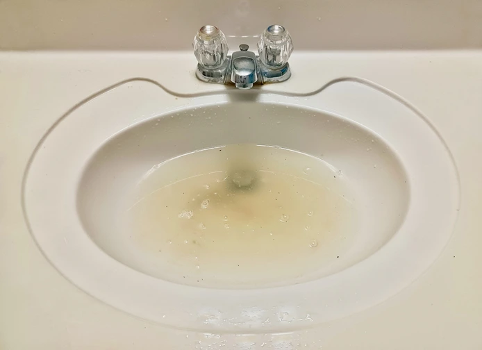 Slow-draining sink showing early warning signs of potential tree root intrusion in sewer line.
